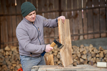 Carpenter using hatchet on walnut wood