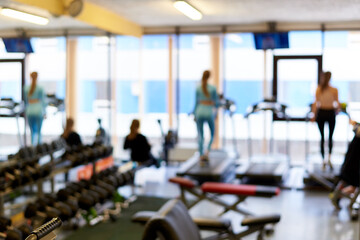 Fototapeta premium Defocused modern gym with exercising people.