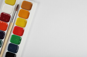 new watercolor paints and brushes for painting on a white background, copy space.