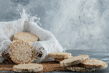 Delicious crispbread and raw buckwheat on marble background