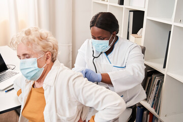 Woman doing regular checkup while examine mature client
