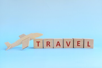 Wooden airplane model with blocks on sky blue background. Travel concept.