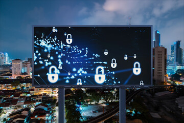 Padlock icon hologram on road billboard over panorama city view of Kuala Lumpur at night to protect business, Malaysia, Asia. The concept of information security shields.