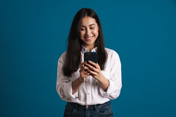 Happy beautiful asian girl smiling and using smartphone