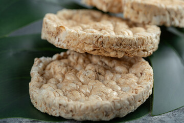 Three puffed rice cakes on green leaf