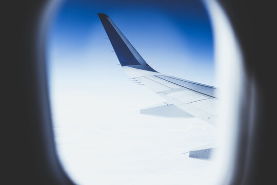 Top view from inside window airplane of a blue sky and wing