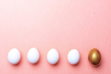 Easter background. Golden, white colour egg on pastel pink background in Happy Easter decoration. Spring holiday top view concept.