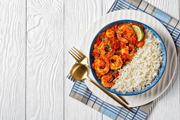 Tomato prawn curry with rice, top view, copy space