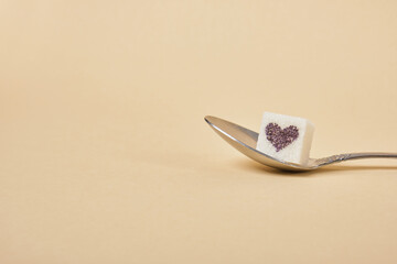 spoon full of sugar cubes on biege background