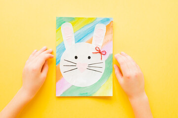 DIY Easter card. How to make paper bunny for Easter greetings. Step by step photo instruction. Kids hands hold Finished card. Step 7.