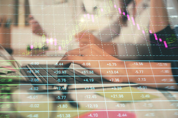 Multi exposure of woman hands typing on computer and financial graph hologram drawing. Stock market...