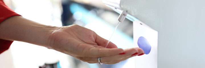 Woman disinfect hand close-up. Non-contact device for killing infection in public place.