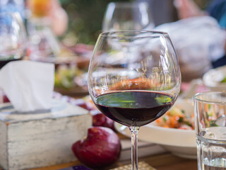 Red wine in the wineglass on the dinner table. Close-up photo. Concept of beverages and relaxation