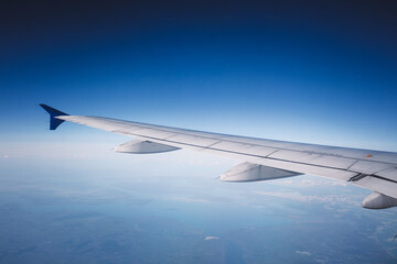 Fototapeta na wymiar Top view from inside window airplane of blue sky and wing
