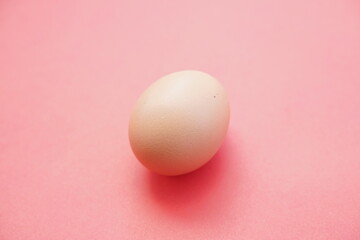 Eggs isolated on pink background give a warm effect. Eggs face the side. Egg wallpaper. Design, visual arts, minimalism. Egg template. Organic chicken egg concept. The concept of healthy organic food.