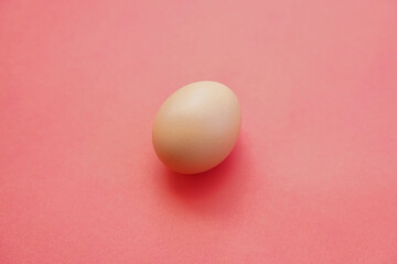 Eggs isolated on pink background give a warm effect. Eggs face the side. Egg wallpaper. Design, visual arts, minimalism. Egg template. Organic chicken egg concept. The concept of healthy organic food.