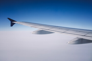 Top view from inside window airplane of blue sky and wing