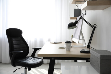 Comfortable office chair near table with modern computer