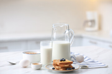 Toasted bread with jam and blueberries on white marble table in kitchen