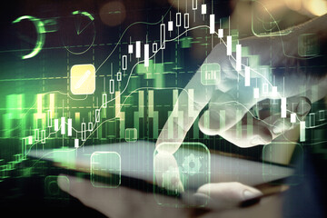 Obraz premium Double exposure of man's hands holding and using a digital device and forex graph drawing. Financial market concept.