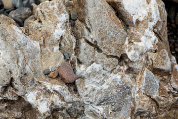 The surface of an old rock with cracks and moss. Old rock texture (wild background)
