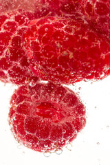 Raspberry in carbonated water on white background