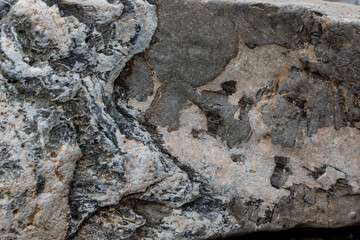 The surface of an old rock with cracks and moss. Old rock texture (wild background)
