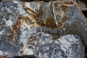 The surface of an old rock with cracks and moss. Old rock texture (wild background)
