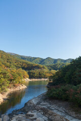 A river flowing between the blue sky and the mountains