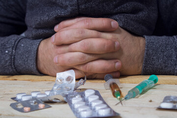 addict next to pills and syringes