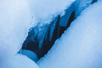 Little hole in the snow and stalactites near Brúarárfoss Waterfall, Iceland, North Atlantic Ocean