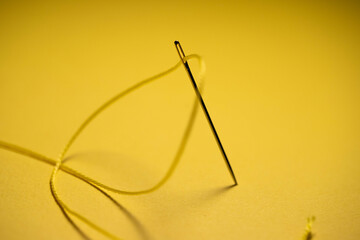 Fototapeta na wymiar yellow thread in a needle