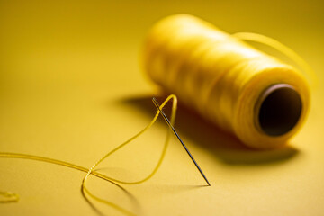 yellow thread in a needle