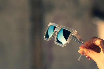 Pixel Model sunglasses hold in hand closeup in a sunny day. Selective focus. High quality photo