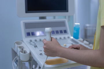 Hands of doctor working at the ultrasound device, Echocardiography.