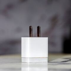 Charging for phone on blurred background. Block, energy
