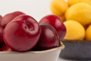Red round plum and apricot in bowls