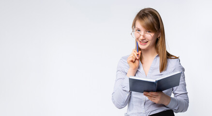 Banner- long format. Beautiful female teacher in formal wear writing in notebook and looking at...