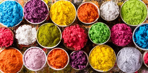 Fröhliche Holi-Dekoration, das indische Fest. Draufsicht auf buntes Holi-Pulver auf dunklem Hintergrund. © Siam