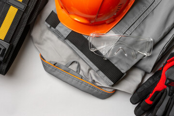 Builder's equipment on a gray table. Builder's uniform, helmet, glasses and gloves	