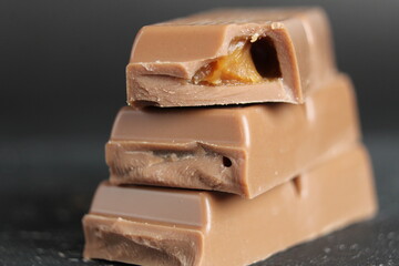 Day chocolate bar pieces of chocolate lie on top of each other with a stack of macro close-ups on a black background