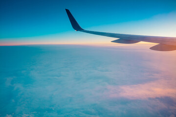 Fototapeta na wymiar Top view from inside window airplane of a sunset sky and wing