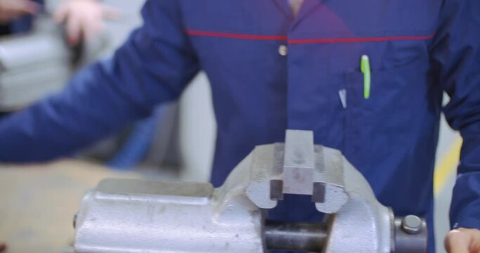 filing iron piece on vice