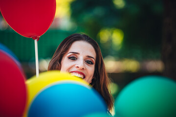 Nice teenager is celebrating her  birthday near balloons