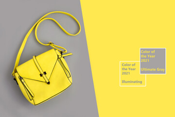 Fashion woman yellow bag on gray background. Trendy Color of Year 2021. Illuminating Yellow and Ultimate Gray. Flat lay, top view. Copy space. Fashionable leather bag