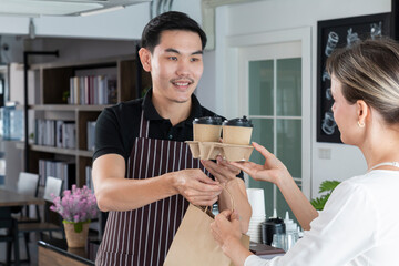 Male bartender serving passing hot drinks to female customer at coffee shop. Barista passing coffee cups to his customer. Small business, people and service concept.