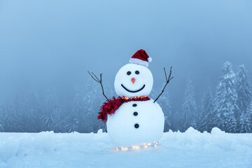 Funny snowman in stylish red hat and red scalf on snowy mountains. Glowing garland for Christmas vibe