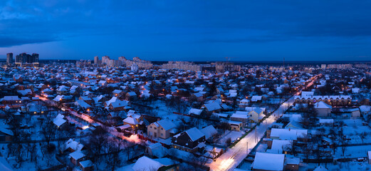 Low-rise suburban buildings, drone view. Night winter cityscape.