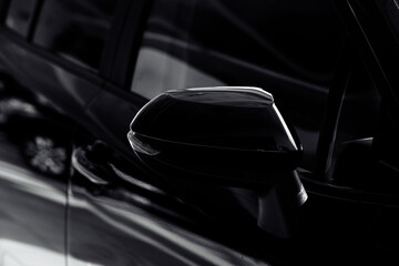 Black side mirror of the car with turn signal repeaters. Exterior new car. Rear-view mirror of black car , black tinted glass.