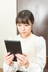 Woman sitting in a chair and holding a tablet